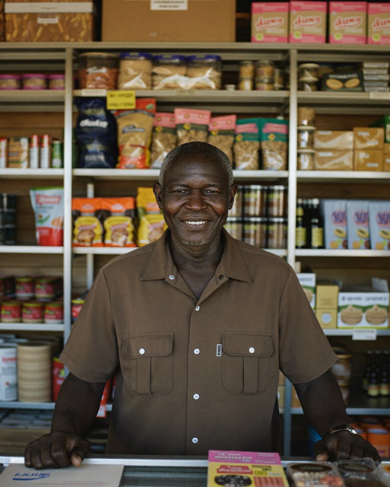 Shopkeeper serving a customer at a Kenyan retail counter